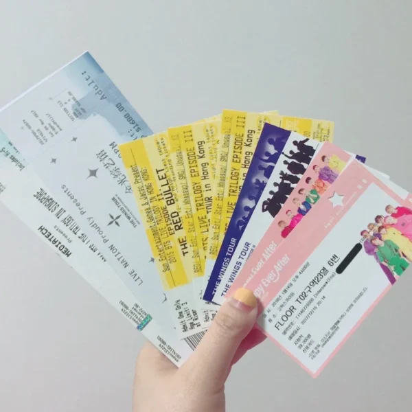 A collection of concert tickets in a hand