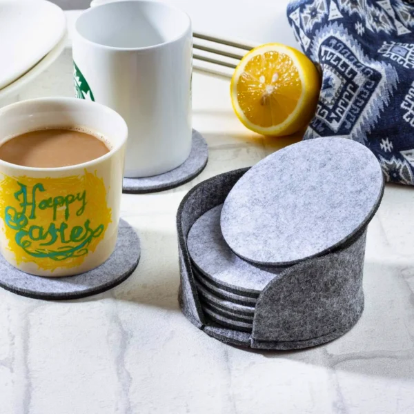 Gray felt drink coasters and a mug on a table.