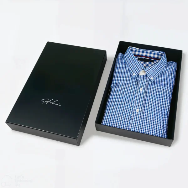 Black box with a neatly folded blue checked shirt inside.