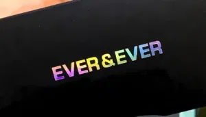 Holographic foiling on a black background displaying the text "EVER & EVER" in colorful letters.
